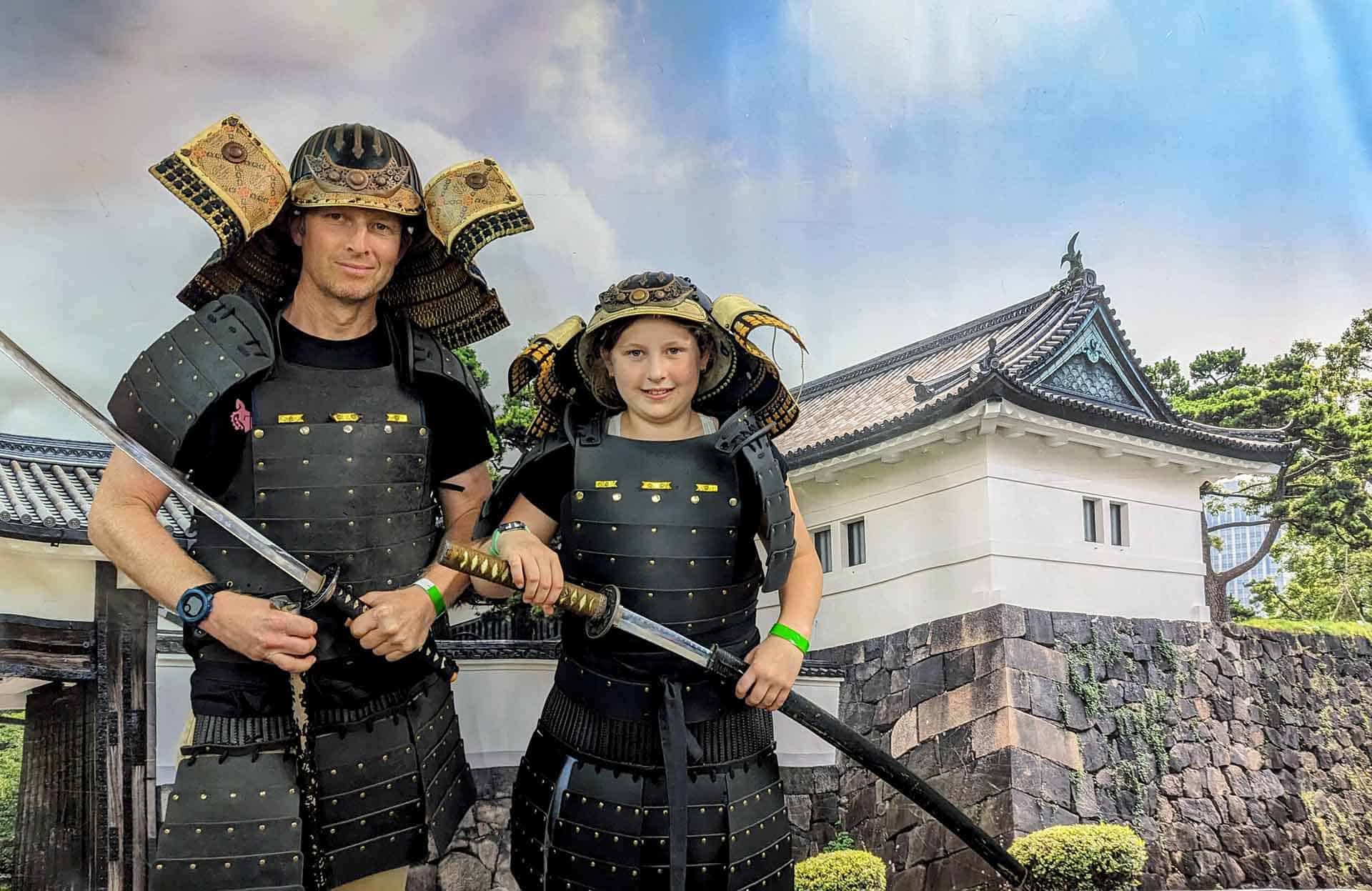Bike Odyssey founder Sam Wood and daughter posing in Samurai armour and with katana in Kyoto, Japan
