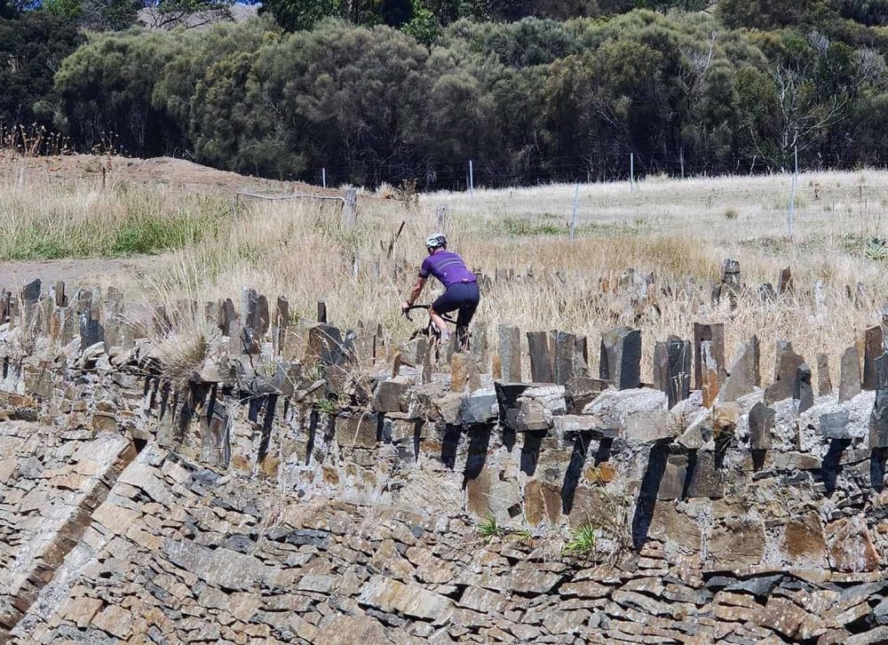 Cyclist riding over convict built Spikey Bridge on the east coast of Tasmania